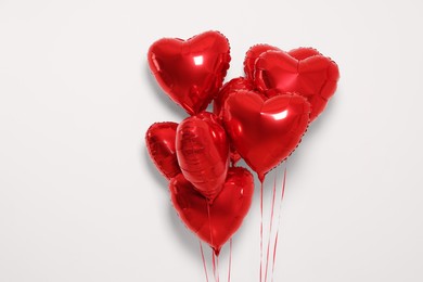Photo of Many red heart shaped balloons on white background
