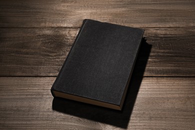 Photo of One old hardcover book on wooden table