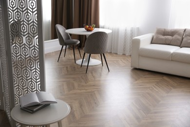 Modern living room with parquet floor and stylish furniture