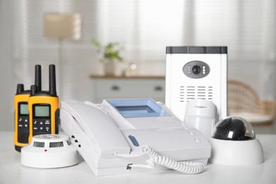 Different equipment for home security system on white table indoors