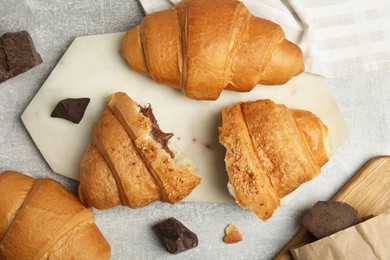 Flat lay composition with tasty croissants and chocolate on light grey table
