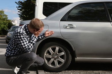 Photo of Stressed man near car with scratch outdoors