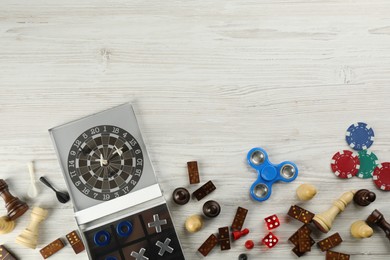 Elements of different board games on white wooden table, flat lay. Space for text