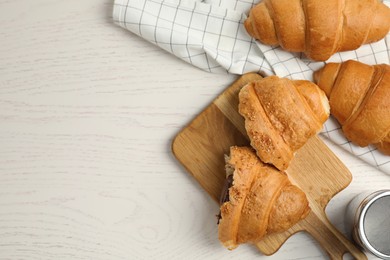 Tasty croissants with chocolate on white wooden table, flat lay. Space for text