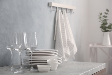 Set of clean dishware and wineglasses on grey table indoors. Space for text