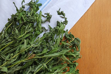 Bunches of wilted mint on wooden table, flat lay. Space for text