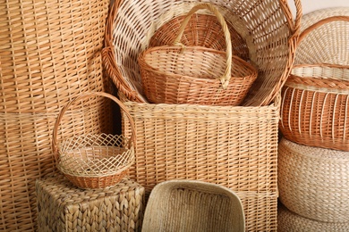 Many different wicker baskets made of natural material as background, closeup