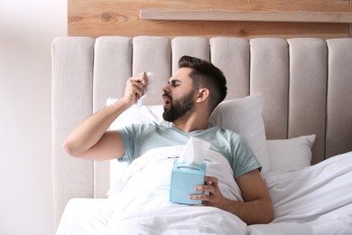 Man suffering from runny nose in bed
