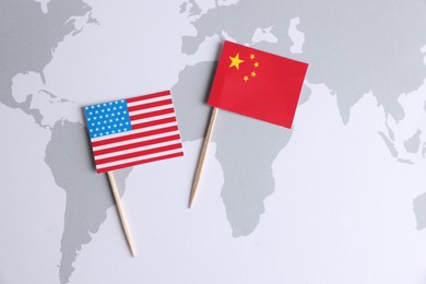 American and Chinese flags on world map, top view. Trade war concept