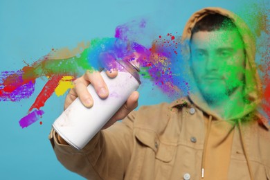 Handsome man spaying paint against light blue background