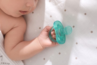 Little baby with pacifier in bed, closeup