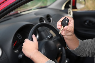 Photo of Man showing car key from new automobile, closeup