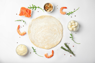 Flat lay composition with dough and fresh ingredients for seafood pizza on white background