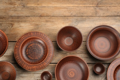 Set of clay utensils on wooden table, flat lay