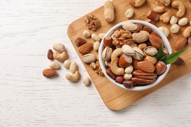 Bowl with organic mixed nuts on table, top view