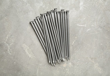 Photo of Many metal nails on grey background, flat lay