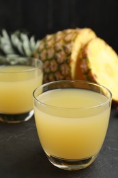 Photo of Delicious fresh pineapple juice on black table