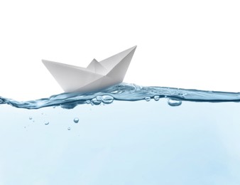 Handmade paper boat floating on clear water against white background 