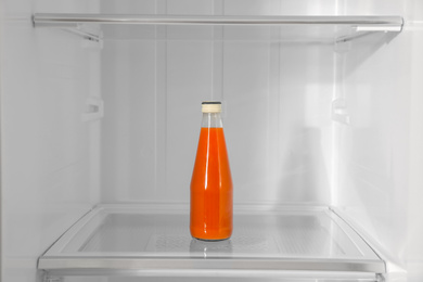 Bottle of juice on shelf inside modern refrigerator
