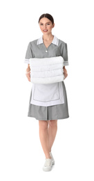Young chambermaid holding stack of fresh towels on white background