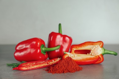 Fresh chili and bell peppers with paprika powder on grey table