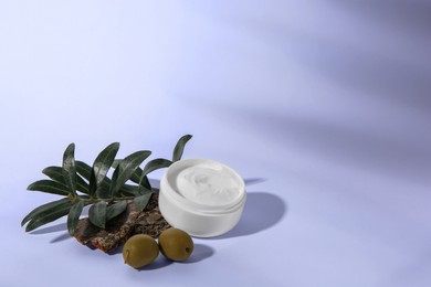 Photo of Jar of natural cream, stones and olives on white background, space for text. Cosmetic products