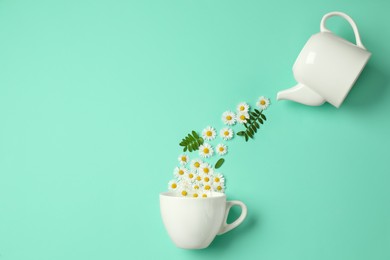 Flat lay composition with beautiful daisy flowers, leaves, ceramic cup and teapot on turquoise background