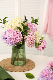 Bouquet of beautiful hydrangea flowers on white table indoors. Interior design