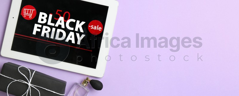 Tablet with Black Friday announcement, gifts and perfumes on violet background, flat lay with space for text. Banner design