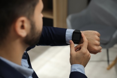 Businessman with smart watch in office, closeup