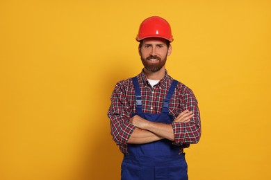 Professional builder in uniform on yellow background