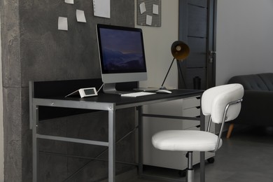 Photo of Stylish room interior with comfortable workplace near grey wall
