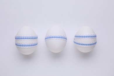 Photo of Festively decorated Easter eggs on white background, top view