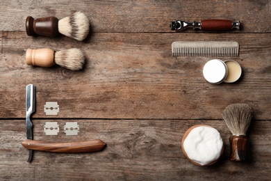 Flat lay composition with men's shaving accessories and space for text on wooden background