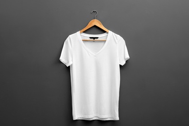 Hanger with blank t-shirt on grey background. Mockup for design