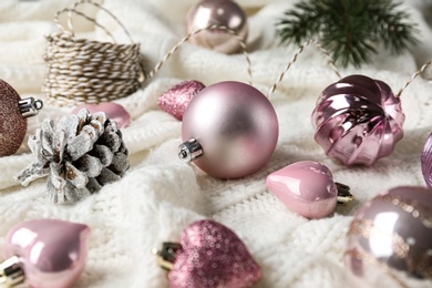 Beautiful pink Christmas baubles on white knitted plaid