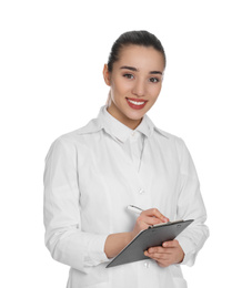 Happy young woman in lab coat with clipboard on white background