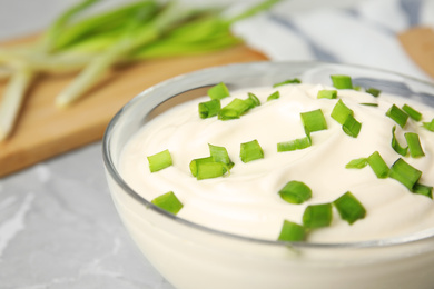 Fresh sour cream with onion in glass bowl, closeup