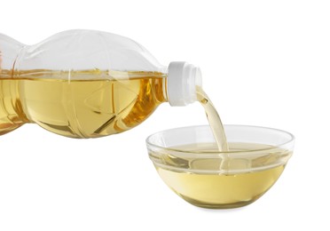 Photo of Pouring cooking oil from bottle into bowl on white background, closeup