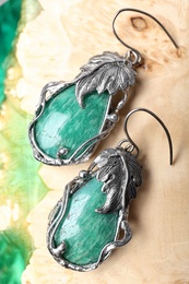 Beautiful pair of silver earrings with amazonite gemstones on textured surface, closeup