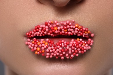 Photo of Young woman with beautiful lips covered confectionery sprinkles, closeup