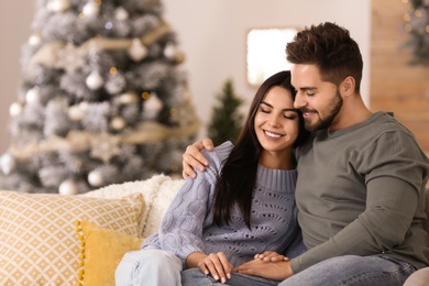 Photo of Happy couple in living room decorated for Christmas