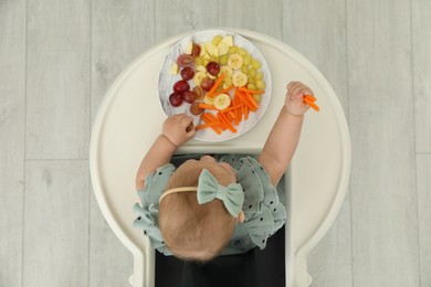Cute little girl eating healthy food, top view