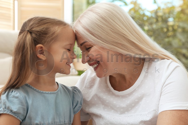 Happy grandmother spending time with her granddaughter at home