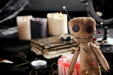 Voodoo doll pierced with pins on table indoors, closeup. Space for text