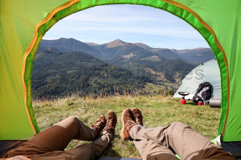 Photo of Couple resting inside of camping tent in mountains, closeup