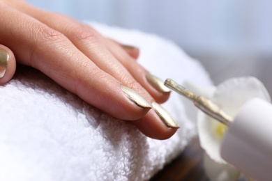 Woman getting manicure in salon, closeup. Nail polish trends