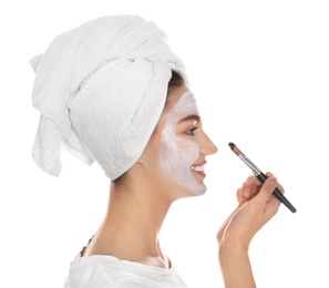 Photo of Happy young woman applying organic mask on her face against white background
