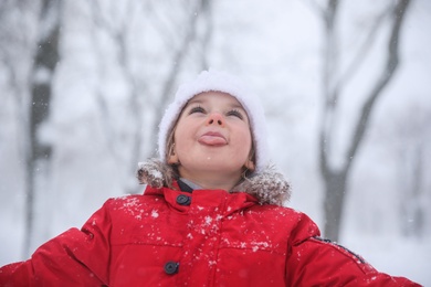 Cute little child having fun outdoors on winter day. Christmas vacation