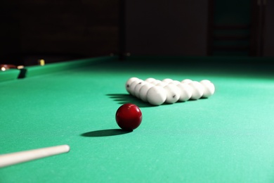 Striking ball with cue on billiard table
